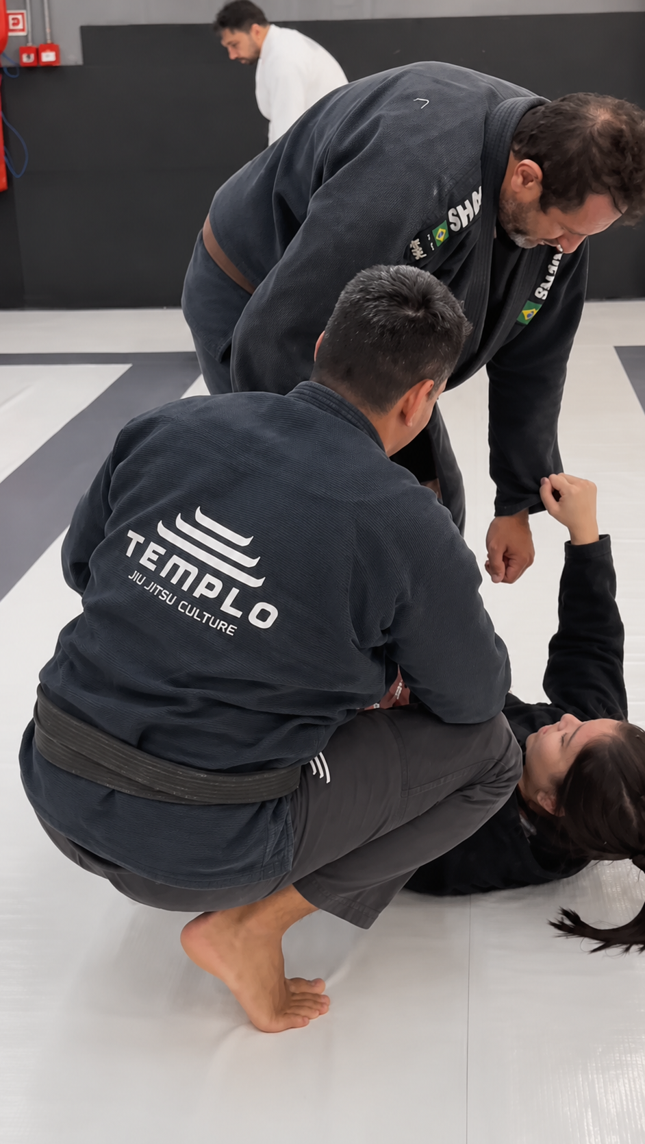Roberto Ichihara orientando a execução técnica de uma aluna no tatame